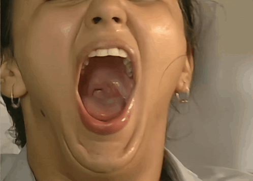 A Close Up Of A Woman With Her Mouth Wide Open GIF