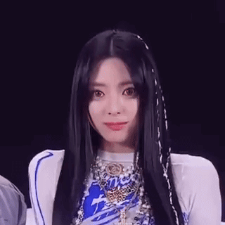 A Close Up Of A Woman With Long Black Hair Wearing A Blue And White Outfit . GIF