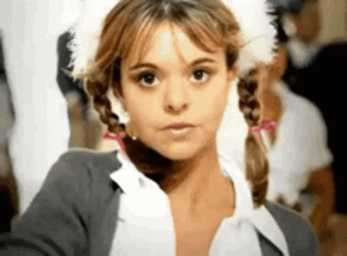 A Close Up Of A Woman With Pigtails And A Feathered Hat . GIF