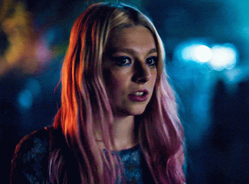 A Close Up Of A Woman With Pink Hair And Blue Eyes GIF