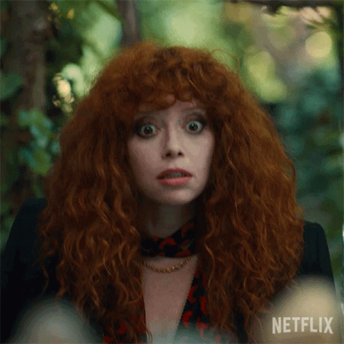 A Close Up Of A Woman With Red Hair And A Netflix Logo GIF