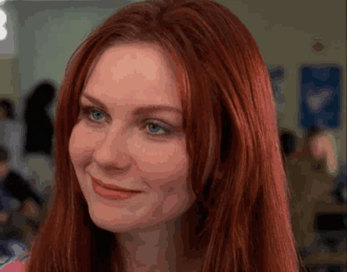 A Close Up Of A Woman With Red Hair And Blue Eyes GIF