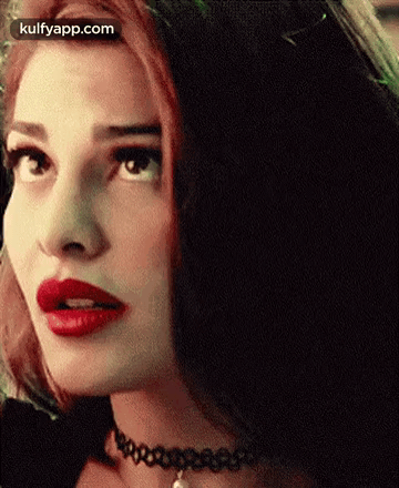 A Close Up Of A Woman With Red Lipstick And A Choker On Her Neck . GIF