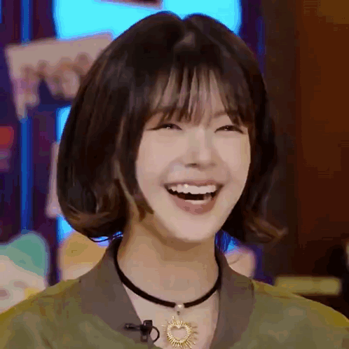 A Close Up Of A Woman With Short Hair And A Choker Laughing . GIF