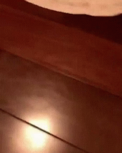 A Close Up Of A Wooden Floor With A Light Shining On It GIF