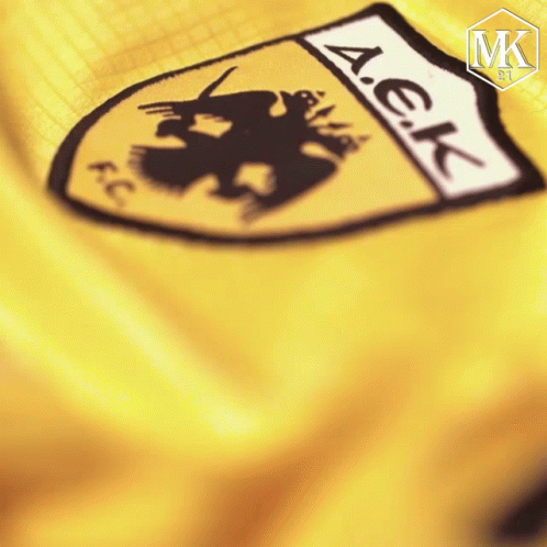 A Close Up Of A Yellow A.e.k. Emblem GIF