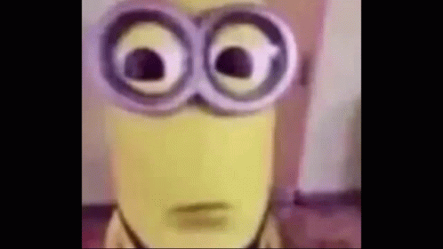 A Close Up Of A Yellow Minion Wearing Glasses . GIF