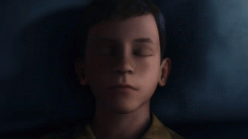 a close up of a young boy 's face against a dark background