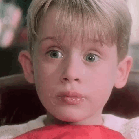 A Close Up Of A Young Boy 'S Face With A Red Scarf Around His Neck And Mouth . GIF