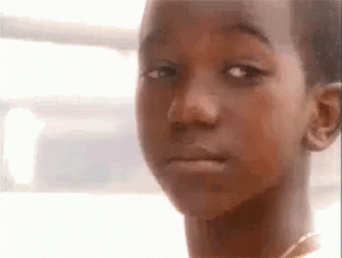 A Close Up Of A Young Boy 'S Face With A Sad Look On His Face . GIF