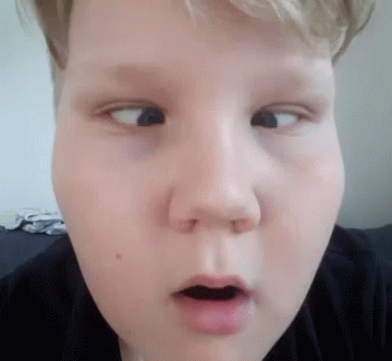 A Close Up Of A Young Boy 'S Face With His Mouth Open Making A Funny Face . GIF