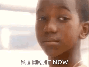 A Close Up Of A Young Boy 'S Face With The Words `` Me Right Now '' Written On It . GIF