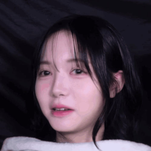 a close up of a young girl 's face with a white towel around her neck