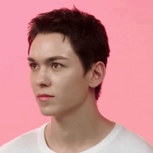 A Close Up Of A Young Man 'S Face Against A Pink Background GIF