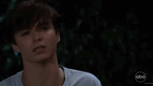 A Close Up Of A Young Man 'S Face In A Dark Room . GIF