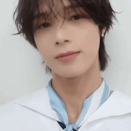 A Close Up Of A Young Man 'S Face Wearing A White Shirt And A Blue Scarf . GIF