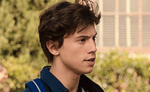 A Close Up Of A Young Man 'S Face With A Backpack On His Back . GIF