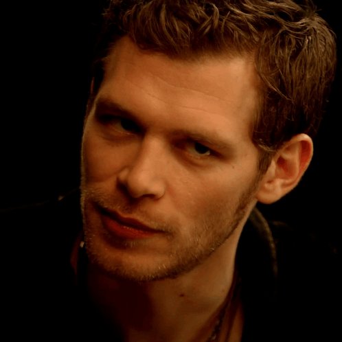 A Close Up Of A Young Man 'S Face With A Black Background GIF