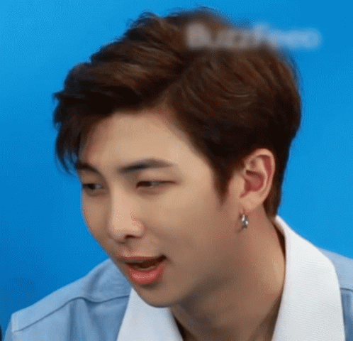 A Close Up Of A Young Man 'S Face With A Blue Background GIF