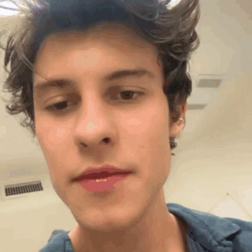 A Close Up Of A Young Man 'S Face With A Blue Shirt GIF