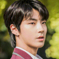 A Close Up Of A Young Man 'S Face With A Blurred Background And A Red Jacket . GIF