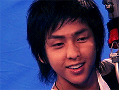 A Close Up Of A Young Man 'S Face With A Camera In The Background GIF
