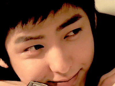 A Close Up Of A Young Man 'S Face With A Cell Phone In His Mouth GIF