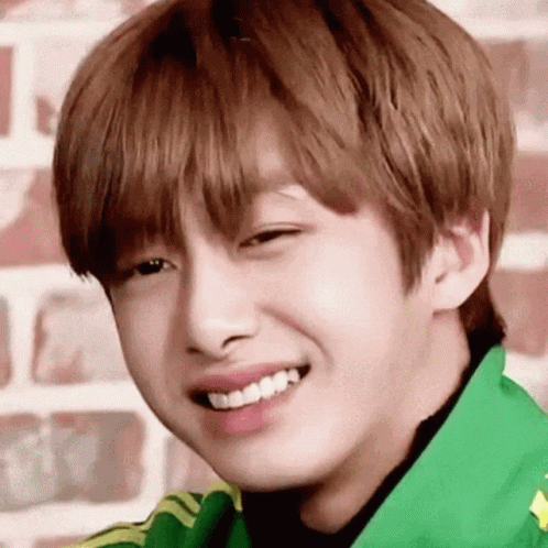 A Close Up Of A Young Man 'S Face With A Green Jacket On . GIF