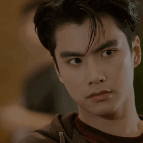 A Close Up Of A Young Man 'S Face With A Hand On His Chin GIF