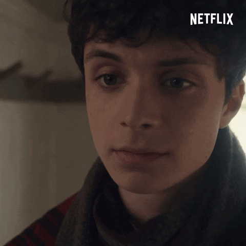 A Close Up Of A Young Man 'S Face With A Netflix Logo In The Background GIF
