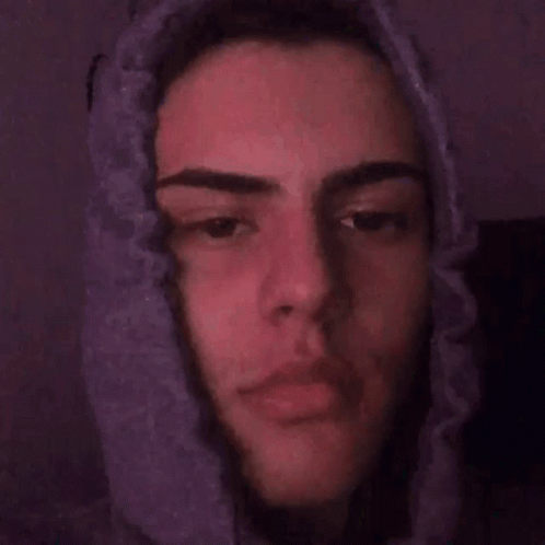 A Close Up Of A Young Man 'S Face With A Purple Background . GIF
