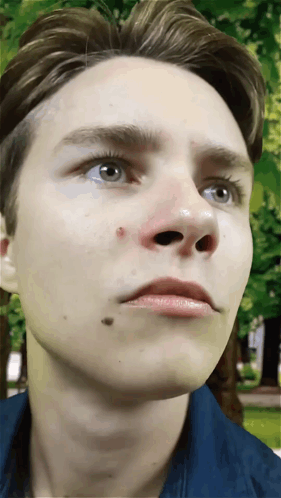 A Close Up Of A Young Man 'S Face With A Red Spot On His Nose GIF