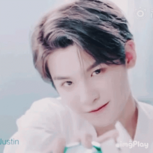 A Close Up Of A Young Man 'S Face With A Smile On His Face And A White Shirt On . GIF