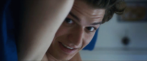 A Close Up Of A Young Man 'S Face With A Smile On His Face GIF