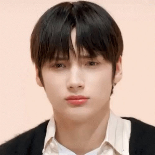 A Close Up Of A Young Man 'S Face With A White Shirt And Black Sweater . GIF