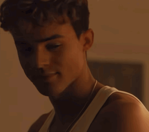 A Close Up Of A Young Man 'S Face With A White Tank Top On GIF
