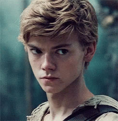 A Close Up Of A Young Man 'S Face With Blonde Hair And A Backpack . GIF