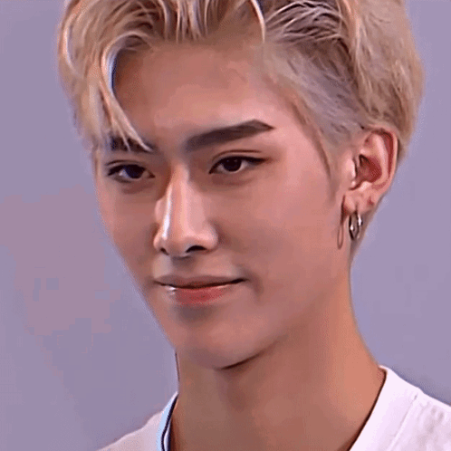 A Close Up Of A Young Man 'S Face With Blonde Hair And Hoop Earrings . GIF