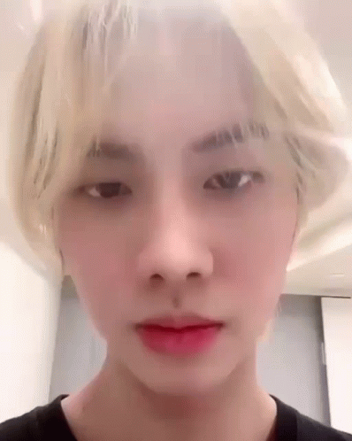 A Close Up Of A Young Man 'S Face With Blonde Hair And Red Lipstick . GIF