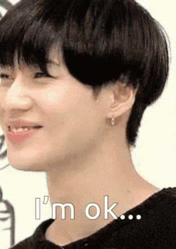 A Close Up Of A Young Man 'S Face With The Words `` I 'M Ok '' Written On It . GIF