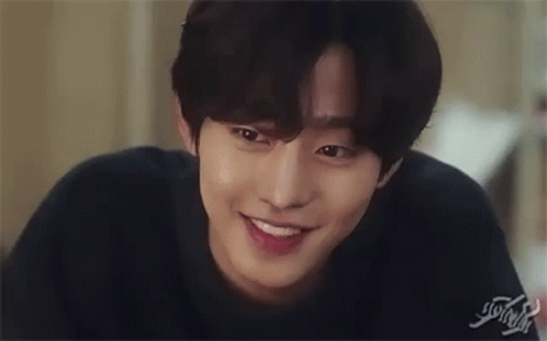 A Close Up Of A Young Man Smiling And Touching His Face . GIF