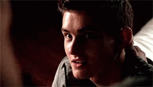 A Close Up Of A Young Man Smiling In A Dark Room . GIF