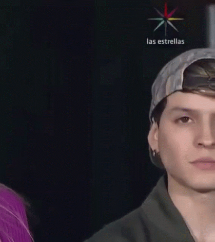A Close Up Of A Young Man Wearing A Baseball Cap And A Black Shirt . GIF