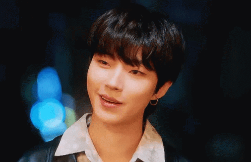 A Close Up Of A Young Man Wearing A Black Jacket And Earrings . GIF