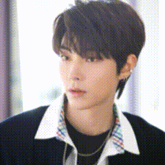 A Close Up Of A Young Man Wearing A Black Shirt And A Plaid Collar . GIF
