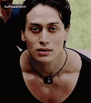 A Close Up Of A Young Man Wearing A Necklace . GIF