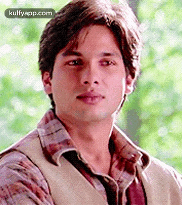 A Close Up Of A Young Man Wearing A Plaid Shirt And Vest . GIF