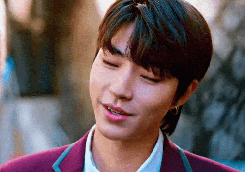 A Close Up Of A Young Man Wearing A Purple Suit And Earrings . GIF