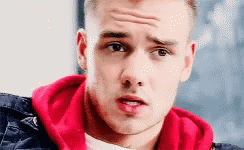 A Close Up Of A Young Man Wearing A Red Hoodie And A Black Jacket . GIF