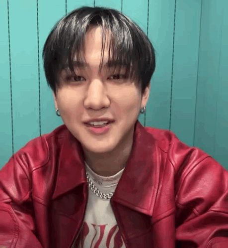 A Close Up Of A Young Man Wearing A Red Leather Jacket And Earrings . GIF